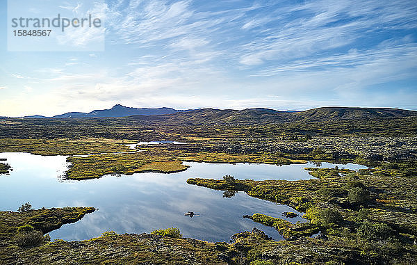 Majestätische Landschaft eines sich windenden Flusses in der Ebene gegen Hochland bei sonnigem Wetter