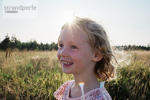 Porträt eines jungen Mädchens  das bei Sonnenuntergang draußen lächelt
