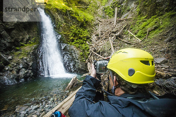 Mann fotografiert großen Wasserfall im Frost Creek Canyon.