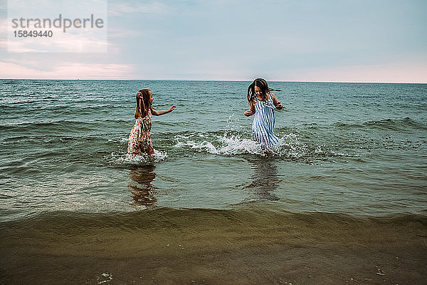 Geschwister planschen und spielen im Wasser am Lake Michigan