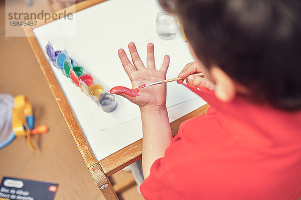 Kinder  die in einem Innenhof spielen und mit Wasserfarben malen