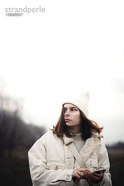 Porträt einer schönen jungen Frau in warmer Kleidung im Freien