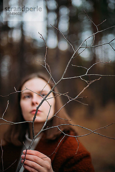 Nahaufnahme einer hübschen jungen Dame im Park stehend mit herabfallendem Baum