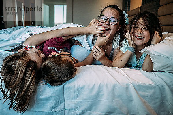 kleine Kinder  die im Urlaub auf dem Hotelbett spielen