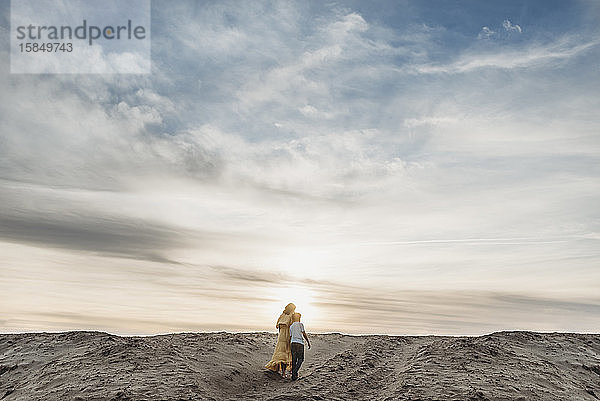 Landschaft einer jungen Mutter und eines schulpflichtigen Sohnes  die am Strand spazieren gehen