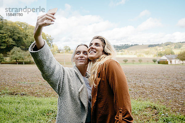 Zwei Freundinnen beim Selfie in einer französischen Landschaft auf dem Land