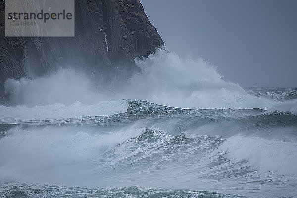 GroÃŸe Wellen von Wintersturm prallen gegen KÃ?stenklippen am Unstad-Strand  VestvÃ¥gÃ¸y  Lofoten  Norwegen