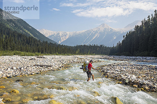 Backpacker überquert eisigen Fluss in Britisch-Kolumbien  Kanada.