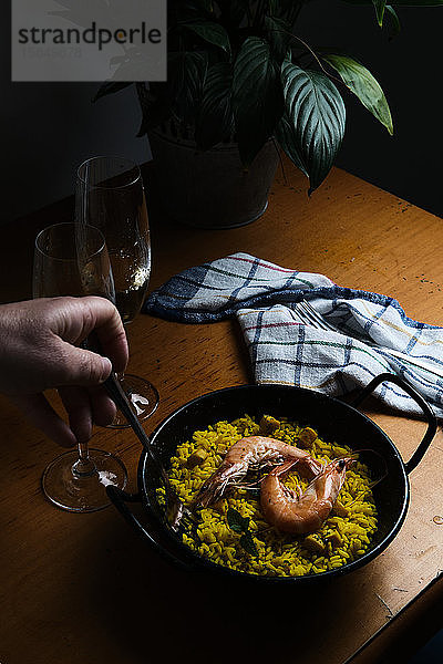 ein Teller mit spanischer Paella für zwei Personen  begleitet von zwei Gläsern