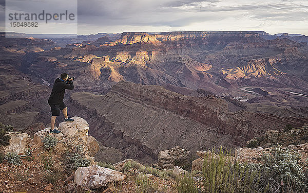 Mann fotografiert Grand Canyon bei Sonnenaufgang