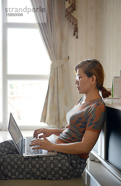 Frau benutzt Computer-Laptop für die Arbeit von zu Hause aus