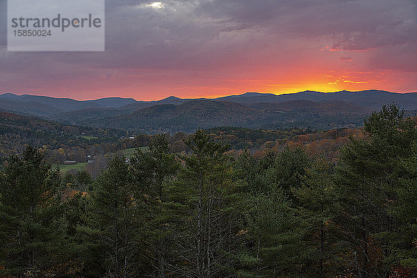 Ein dramatischer Sonnenuntergang hinter Hügeln in der Nähe von Quechee  Vermont.