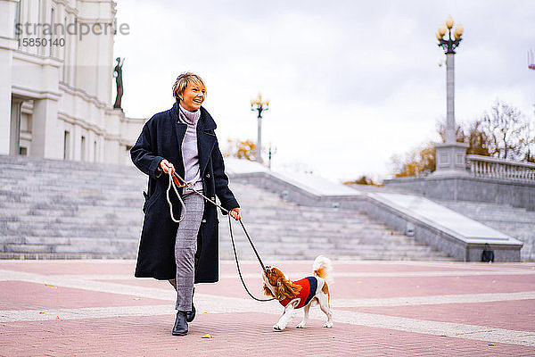 Frau spielt mit einem Cavalier King Charles Spaniel Hund im Freien.