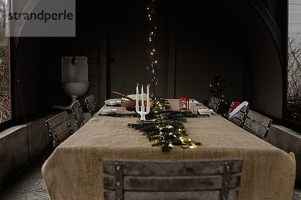 Traditioneller skandinavischer Esstisch mit Lichterketten und Kerzen