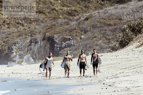 Am Strand stehende männliche Surfer