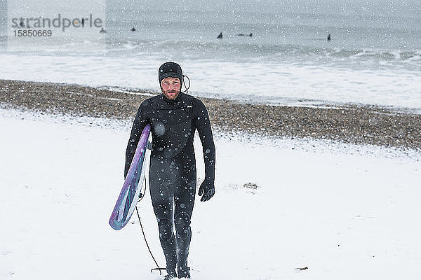 Mann surft im Winterschnee