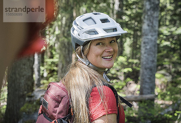 Eine junge Frau lächelt beim Mountainbiken in Oregon.