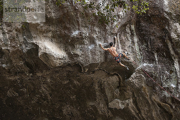Ein tätowierter Mann ohne Hemd beim Klettern in Mexiko