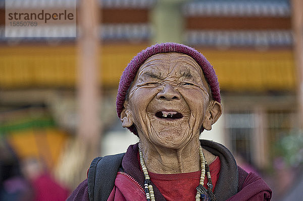 Alte zahnlose Frau lacht bei buddhistischer Feier