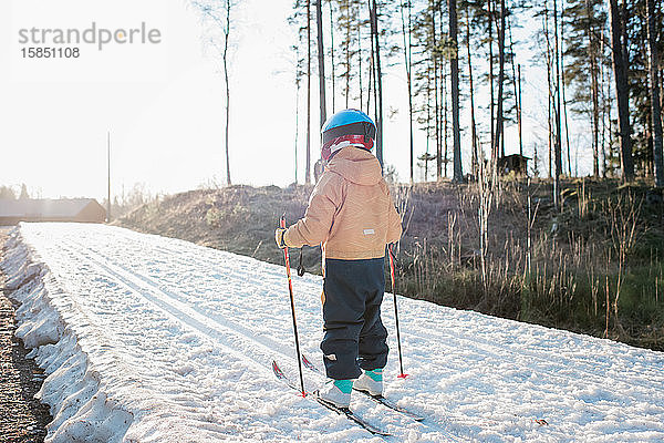 Junge Junge beim Skilanglauf in Schweden bei Sonnenuntergang