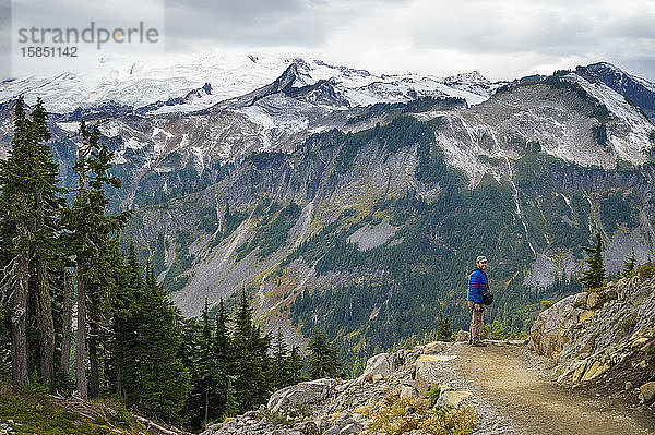 Männlich mit geschwollener Jacke mit Blick auf die Berge