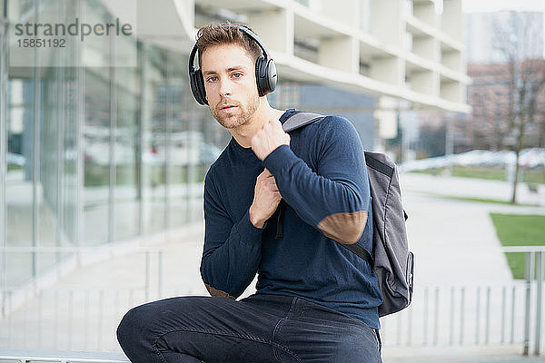 Junger Mann mit Kopfhörern auf der Straße in der Stadt