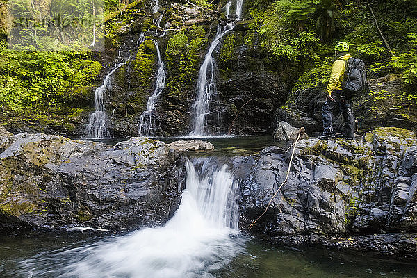 Wanderer betrachtet Wasserfall im Frost Creek Canyon