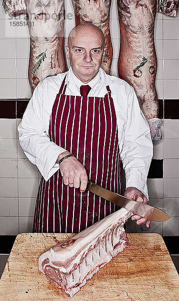 Metzger beim Zerlegen von Fleisch im Laden