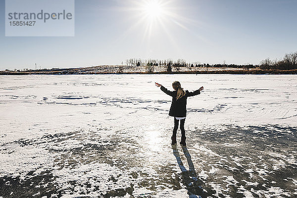 Kleines Mädchen spielt auf gefrorenem See