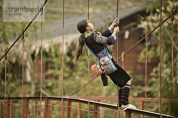 Hmong-Mädchen spielt auf der Dorfbrücke