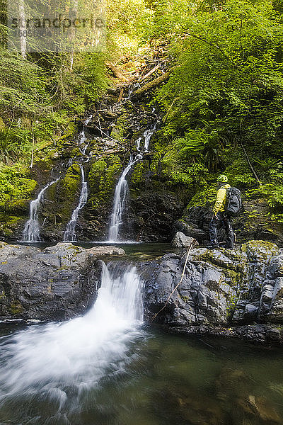 Wanderer betrachtet Wasserfall im Frost Creek Canyon