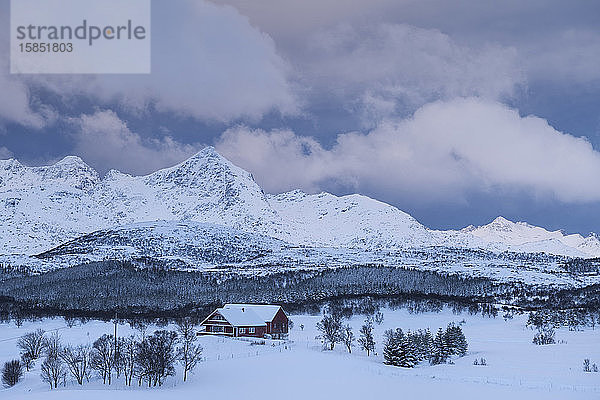 Rotes Haus in schneebedeckter Winterlandschaft von VestvÃ¥gÃ¸y  Lofoten-Inseln  Norwegen