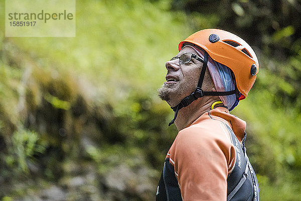 Porträt eines Mannes mit Kletterhelm und Neoprenanzug.