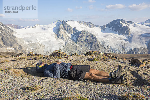 Wanderer auf Berggipfel liegend  erschöpft nach einem langen Tag