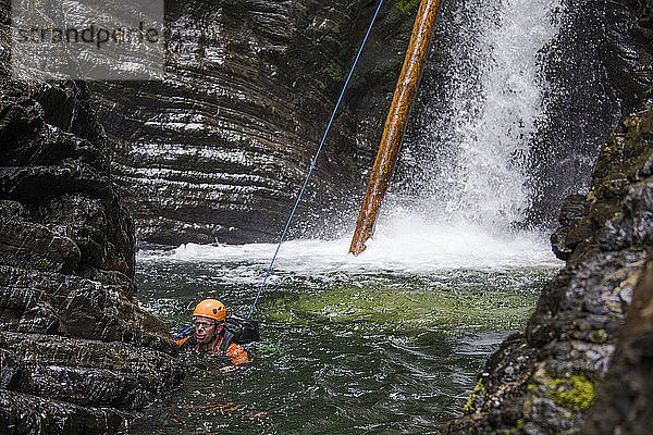 Mann schwimmt nach Abseilen des Wasserfalls in Sicherheit.