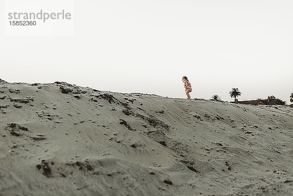 Weite Ansicht eines Kleinkindes  das am Strand im Sand läuft