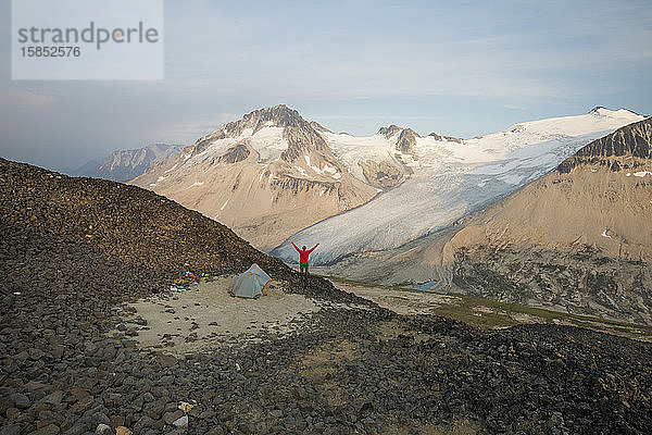 Wanderer hebt die Hände in die Luft  überglücklich über die Aussicht.