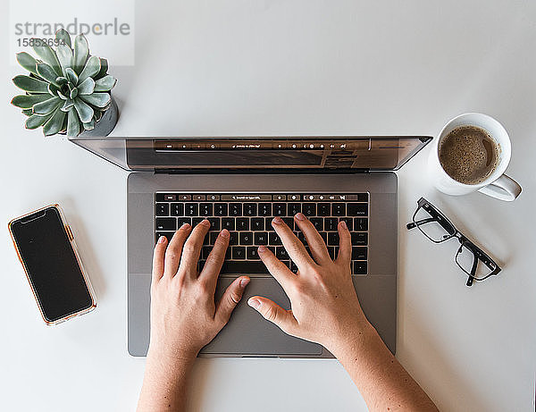 Draufsicht auf die Hände eines Teenagers  der am Laptop-Computer arbeitet.