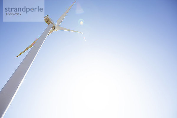 Windturbine gegen blauen Himmel mit Sonneneruption