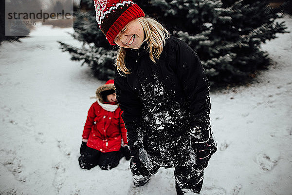 Junges Mädchen lacht beim Spielen im Schnee