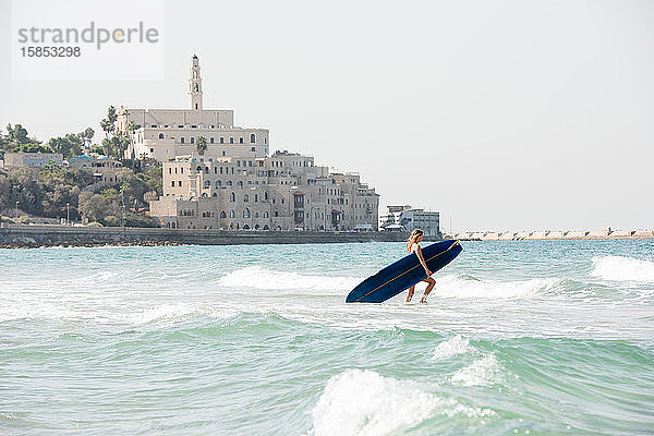 Surft als weibliche Surferin in Israel in die Wellen