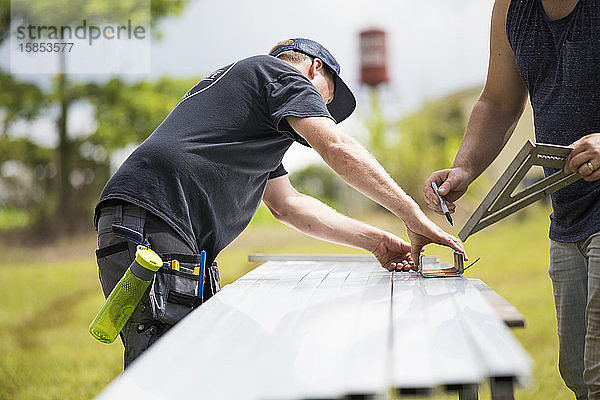 Zwei Männer markieren Messungen der Stahlauslenkung für Sonnenkollektoren.