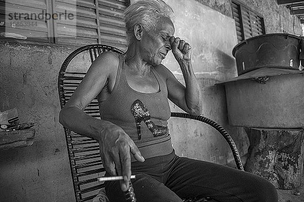 Ältere Frau aus einem brasilianischen Quilombo  die jammert und raucht