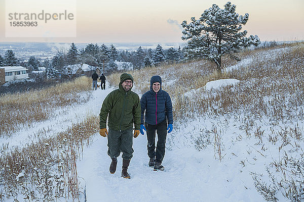 Freunde wandern auf schneebedecktem Pfad in der Dämmerung über Boulder  Colorado