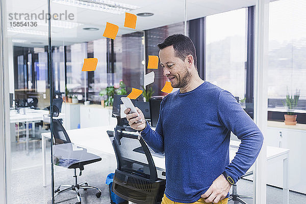 Geschäftsmann benutzt Mobiltelefon im Büro