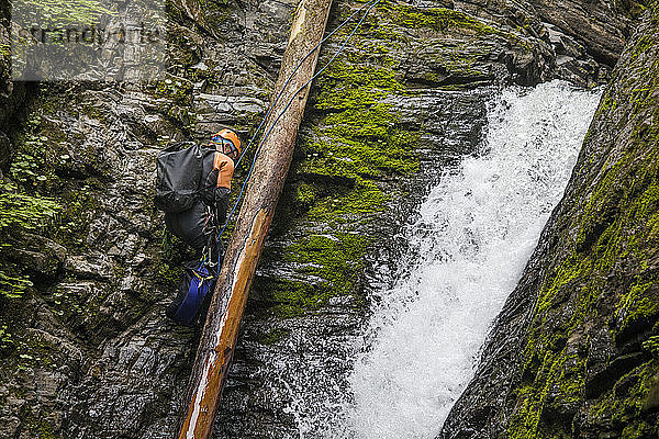 Mann seilt sich neben einem Wasserfall im Frost Creek Canyon ab.