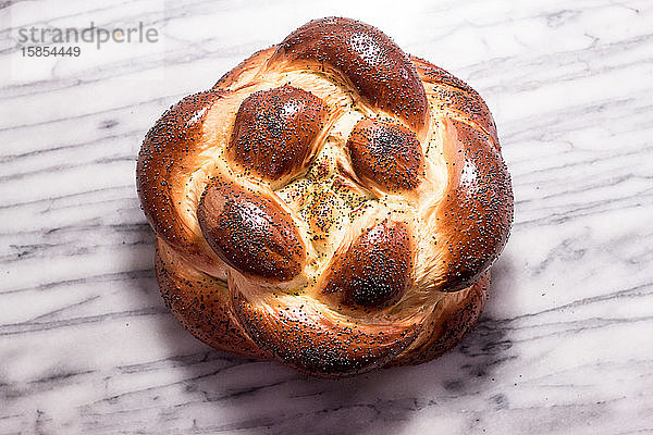 Geflochtener runder Challah-Brotlaib mit Mohnsamen