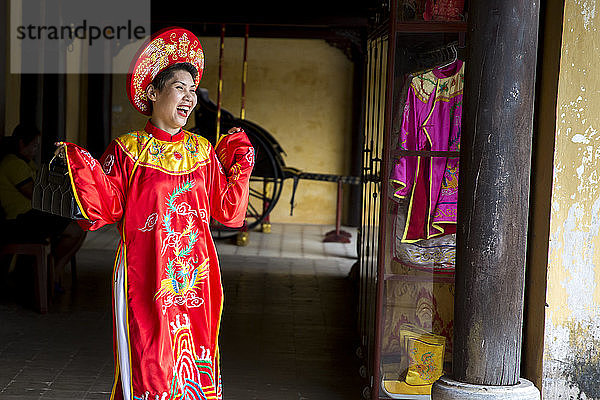 Frau in traditioneller vietnamesischer Kleidung lacht.