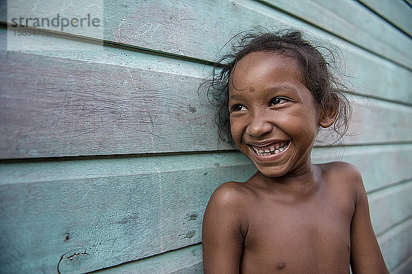 Lächelndes kleines Mädchen vom Amazonas zu Hause  im Freien