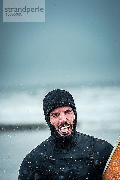 Mann macht ein Gesicht nach dem Surfen während eines Nordoststurms in Maine